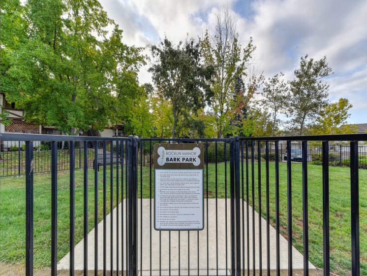 Dog Park Entrance Gate Sign with Gate, Walking Path, Grass and Trees